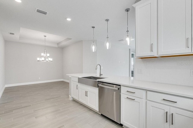 kitchen with stainless steel dishwasher, hanging light fixtures, a raised ceiling, and white cabinets