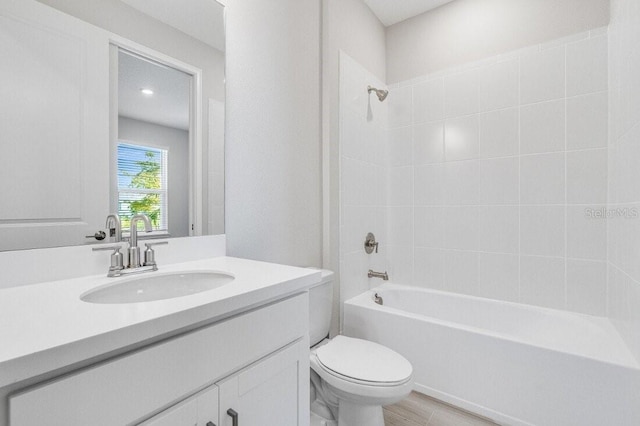 full bathroom featuring toilet, vanity, and tiled shower / bath