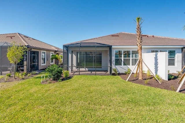 back of house with a lawn and glass enclosure