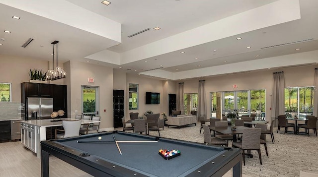 recreation room with a tray ceiling, billiards, and a towering ceiling