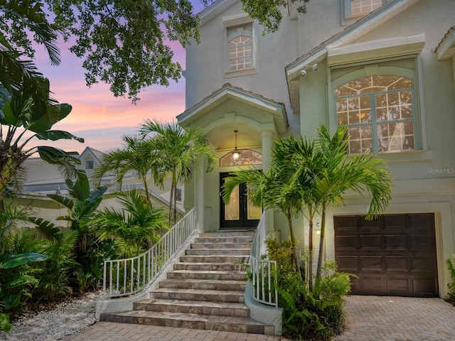 exterior entry at dusk with a garage