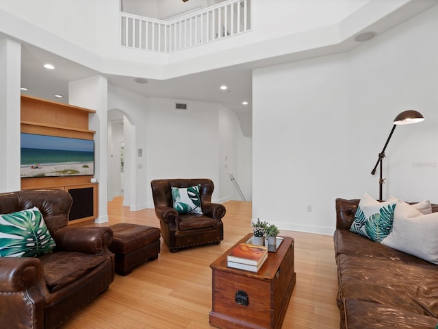 living room featuring a high ceiling and light wood-type flooring