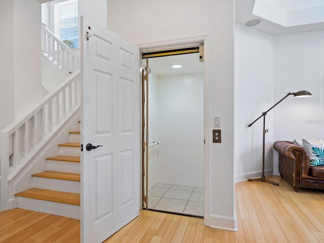 staircase featuring hardwood / wood-style floors and elevator