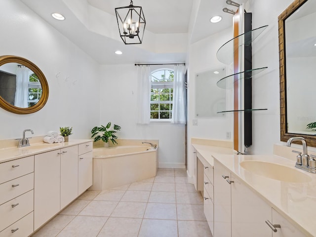 bathroom featuring an inviting chandelier, a bath, tile patterned floors, vanity, and a tray ceiling