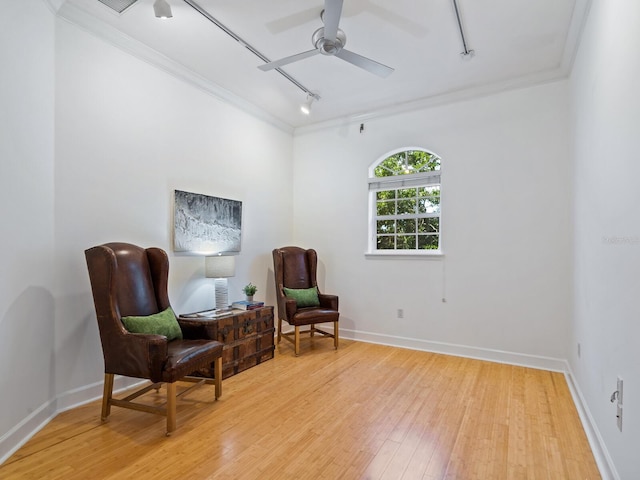 living area with ceiling fan, light hardwood / wood-style flooring, track lighting, and crown molding