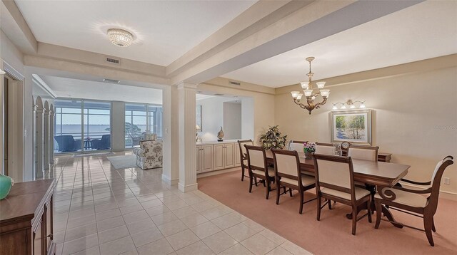 dining room with an inviting chandelier, light tile floors, and decorative columns