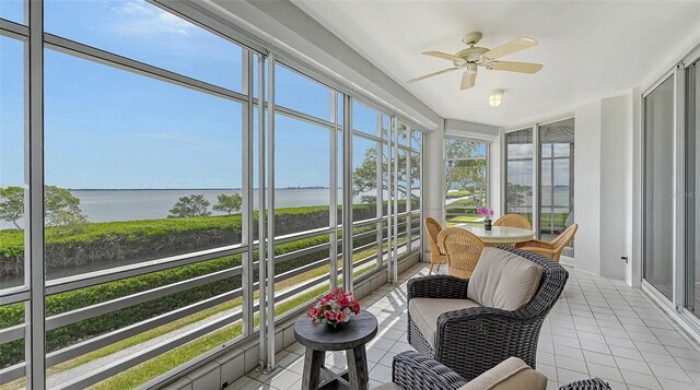 sunroom / solarium with a water view and ceiling fan