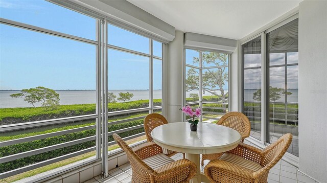 sunroom / solarium featuring a water view