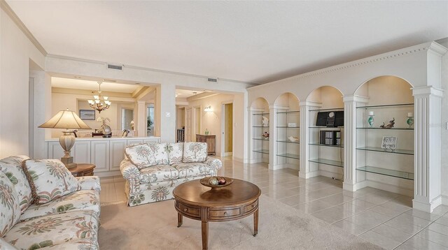 living room featuring ornamental molding, a notable chandelier, light tile floors, and decorative columns