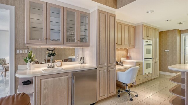 kitchen with white double oven, light tile floors, light brown cabinetry, sink, and refrigerator