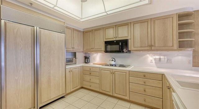 kitchen featuring paneled built in fridge, light tile floors, light brown cabinetry, white dishwasher, and gas cooktop