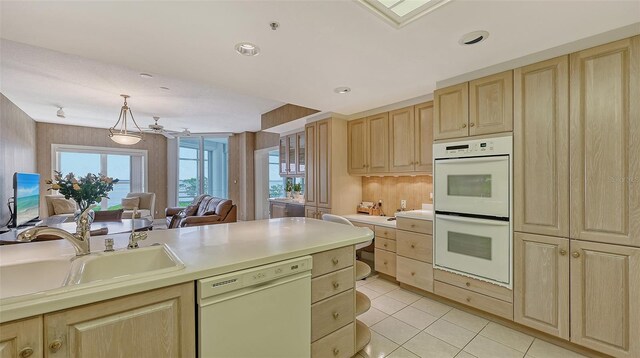 kitchen with sink, plenty of natural light, white appliances, and light tile floors