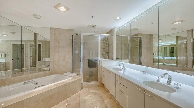 bathroom with plus walk in shower, tile floors, and double sink vanity