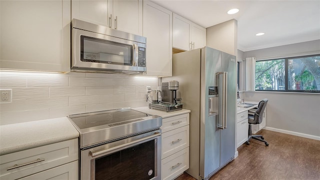 kitchen featuring white cabinets, tasteful backsplash, dark wood-type flooring, crown molding, and stainless steel appliances