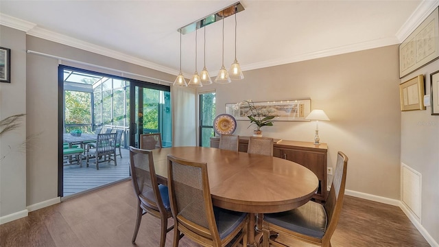 dining area featuring ornamental molding and dark wood-type flooring