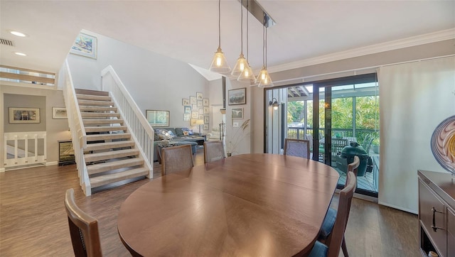 dining area with ornamental molding, dark hardwood / wood-style flooring, and an inviting chandelier