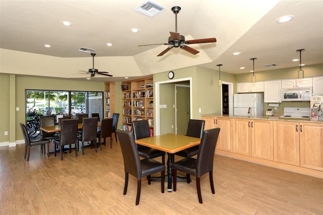 dining room with ceiling fan, light wood-type flooring, and built in features