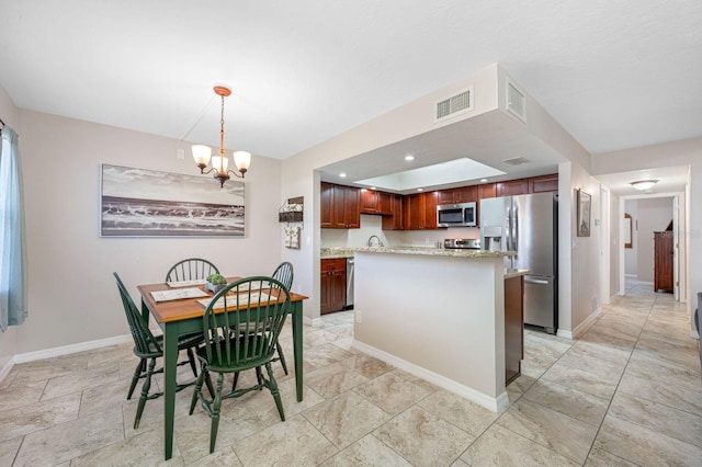 tiled dining room with a chandelier and sink