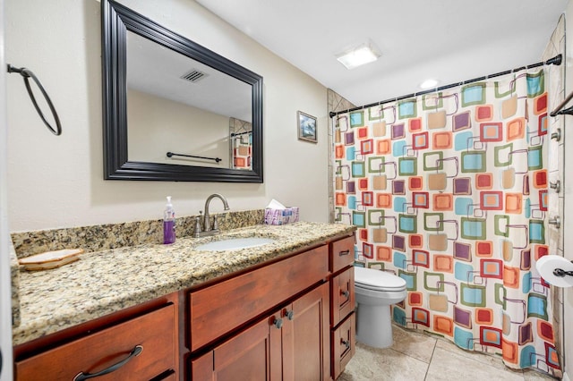 bathroom with vanity, toilet, and tile flooring