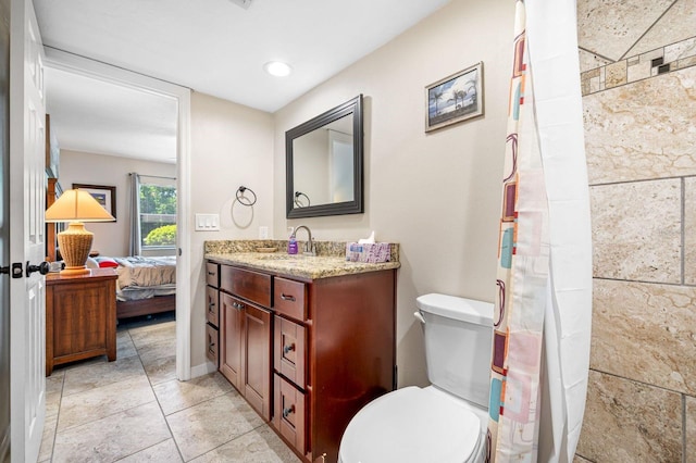 bathroom featuring vanity with extensive cabinet space, toilet, and tile flooring