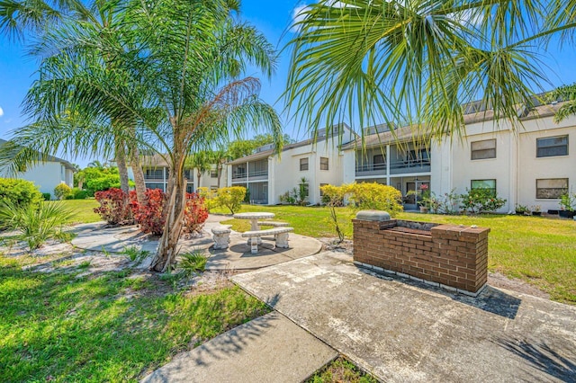 view of front of home with a patio and a front lawn