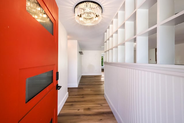 hall with an inviting chandelier and dark wood-type flooring