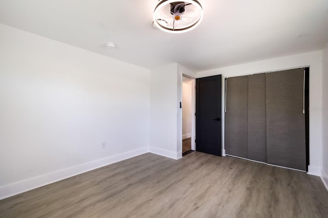 unfurnished bedroom with wood-type flooring and a closet