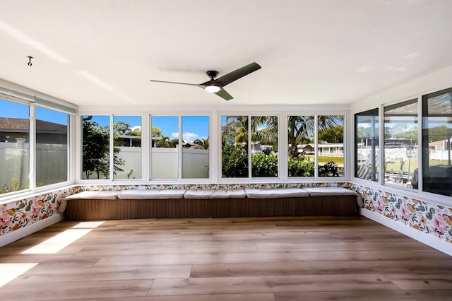 unfurnished sunroom featuring a wealth of natural light and ceiling fan