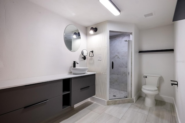 bathroom with tile floors, vanity, an enclosed shower, and toilet