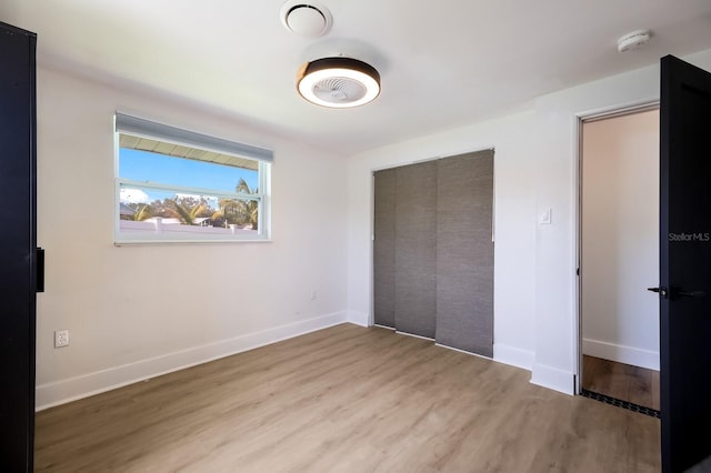 unfurnished bedroom featuring hardwood / wood-style floors and a closet