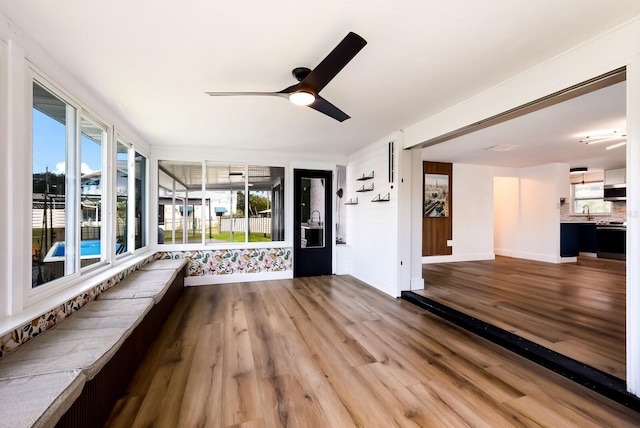 interior space featuring wood-type flooring, sink, ceiling fan, and a healthy amount of sunlight