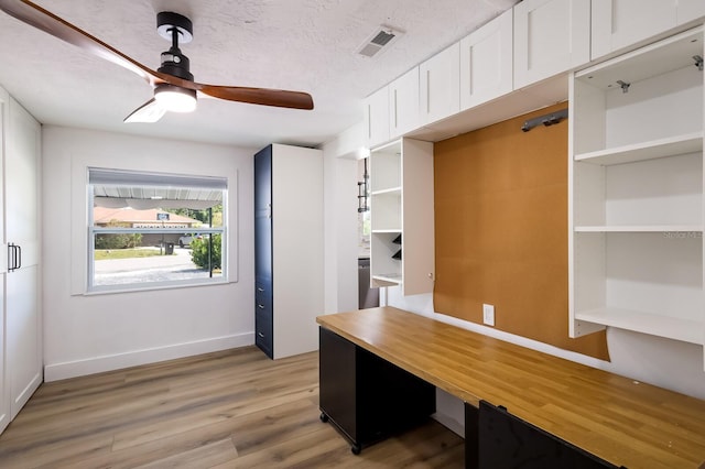 unfurnished office with a textured ceiling, ceiling fan, and light hardwood / wood-style floors