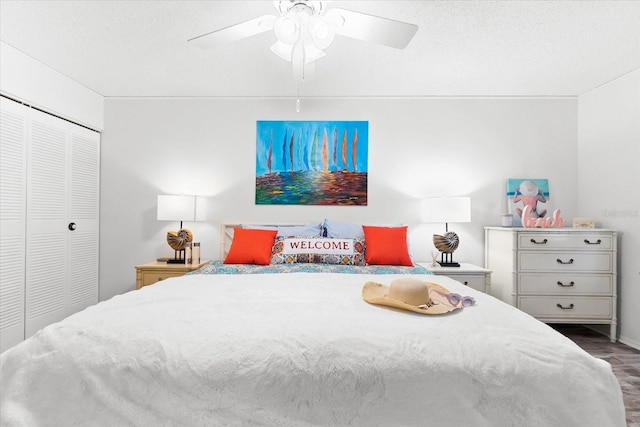 bedroom with a textured ceiling, a closet, ceiling fan, and dark wood-type flooring