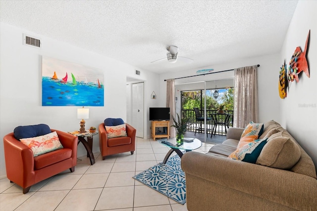 tiled living room featuring ceiling fan and a textured ceiling