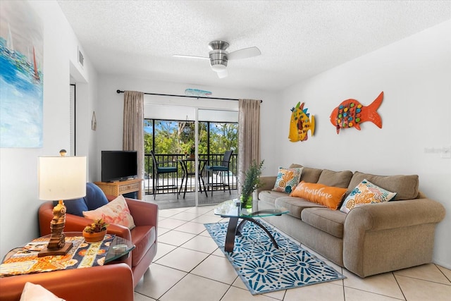 living room with a textured ceiling, ceiling fan, and light tile floors