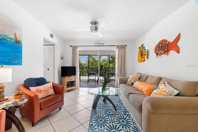 tiled living room featuring ceiling fan and a textured ceiling