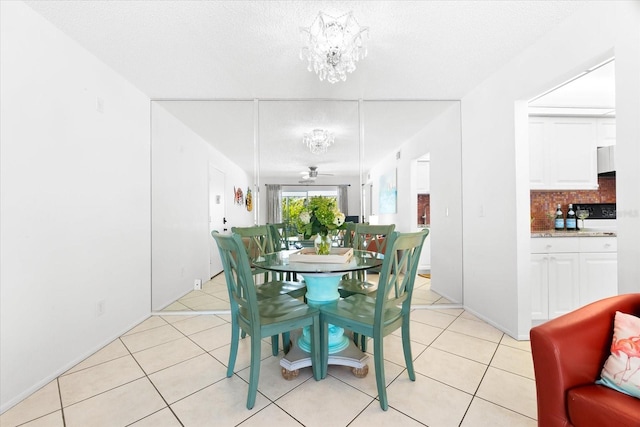 dining room featuring ceiling fan with notable chandelier, light tile floors, and a textured ceiling