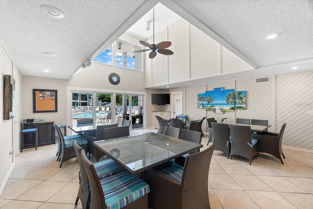 dining room with a textured ceiling, ceiling fan, and light tile floors