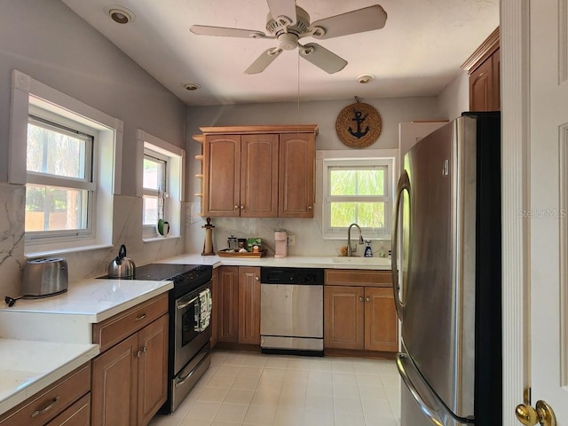 kitchen with appliances with stainless steel finishes, ceiling fan, tasteful backsplash, sink, and light tile floors