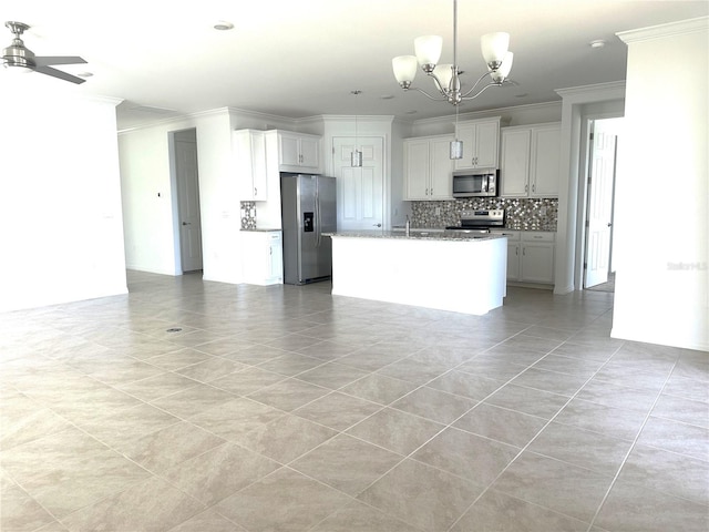 kitchen featuring decorative light fixtures, backsplash, stainless steel appliances, a center island with sink, and white cabinets