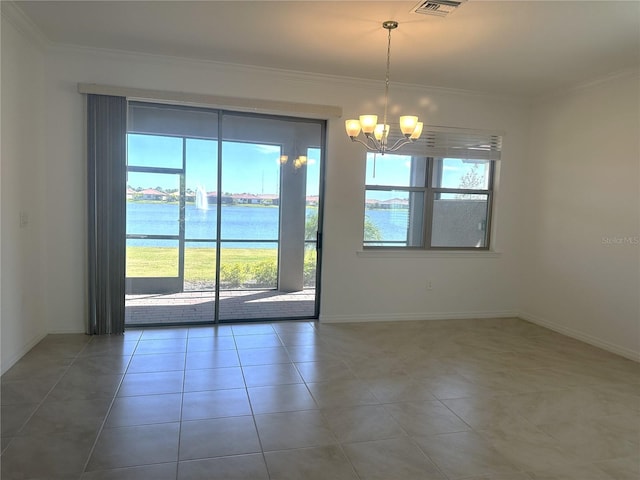 unfurnished room featuring an inviting chandelier, dark tile flooring, crown molding, and a water view