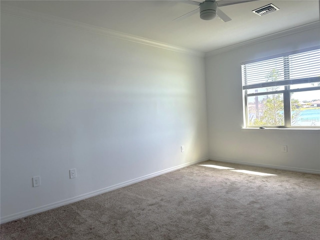 carpeted spare room with ceiling fan and ornamental molding