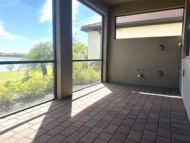 unfurnished sunroom featuring a water view