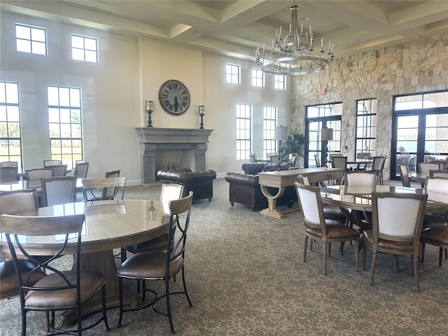 dining room with beamed ceiling, dark carpet, a towering ceiling, a notable chandelier, and coffered ceiling