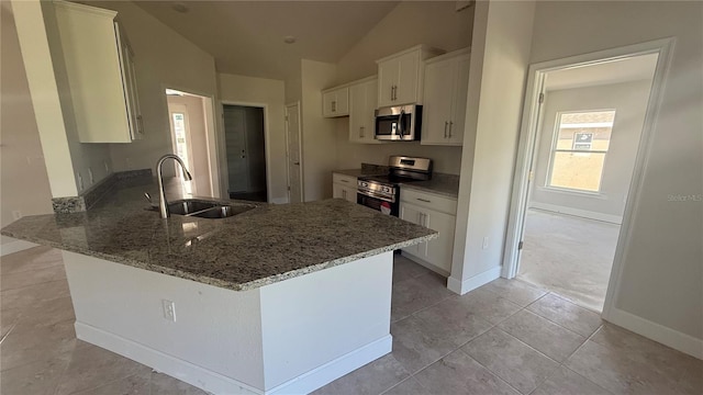 kitchen featuring kitchen peninsula, appliances with stainless steel finishes, sink, white cabinetry, and lofted ceiling