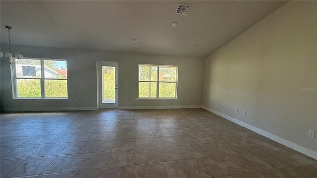 tiled spare room with a notable chandelier and lofted ceiling