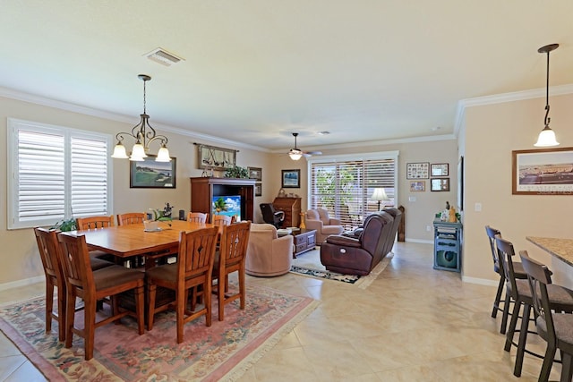 tiled dining room featuring ceiling fan with notable chandelier and ornamental molding