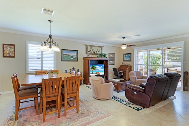 tiled dining space with ceiling fan with notable chandelier and crown molding