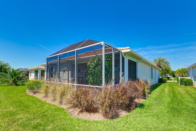 view of side of home featuring a lanai and a yard