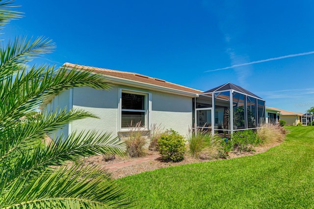 exterior space featuring a lanai and a lawn